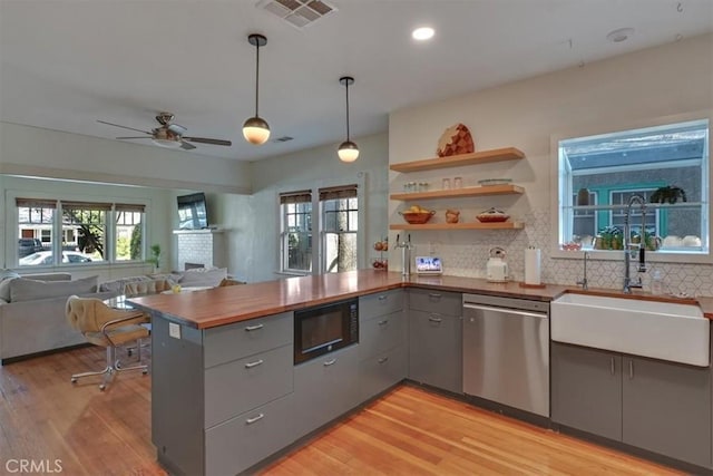 kitchen featuring visible vents, black microwave, dishwasher, gray cabinets, and a sink