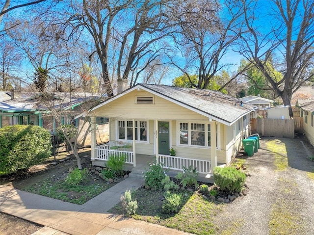 bungalow-style house featuring fence, covered porch, and driveway