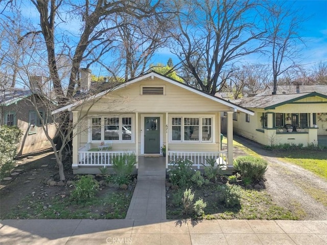 bungalow-style home featuring a porch and a chimney