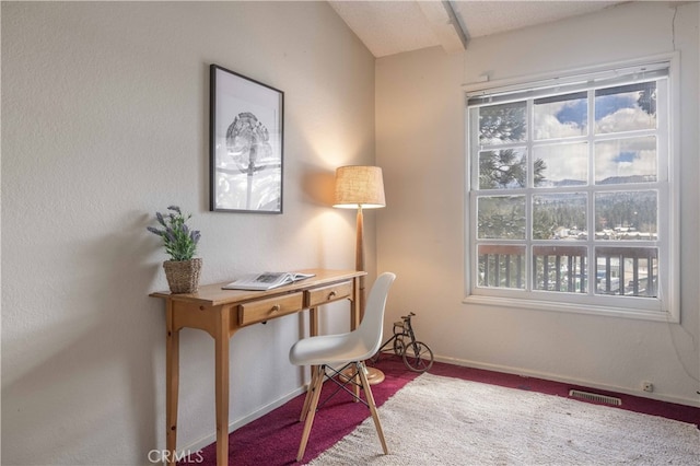 office space featuring a wealth of natural light, carpet, visible vents, and baseboards