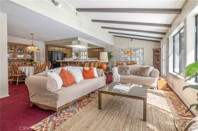 living room featuring lofted ceiling with beams, dark colored carpet, a textured ceiling, and an inviting chandelier