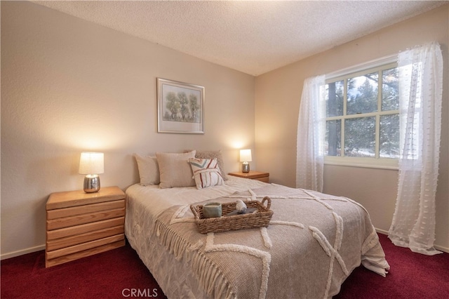 bedroom with dark colored carpet, a textured ceiling, and baseboards