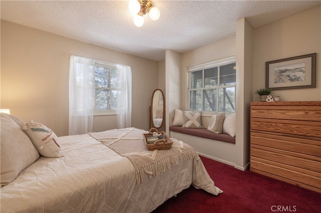 bedroom with dark colored carpet, a textured ceiling, and baseboards