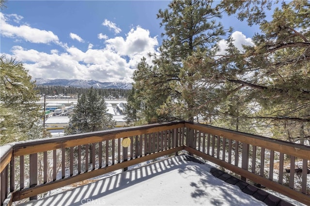 snow covered deck with a mountain view