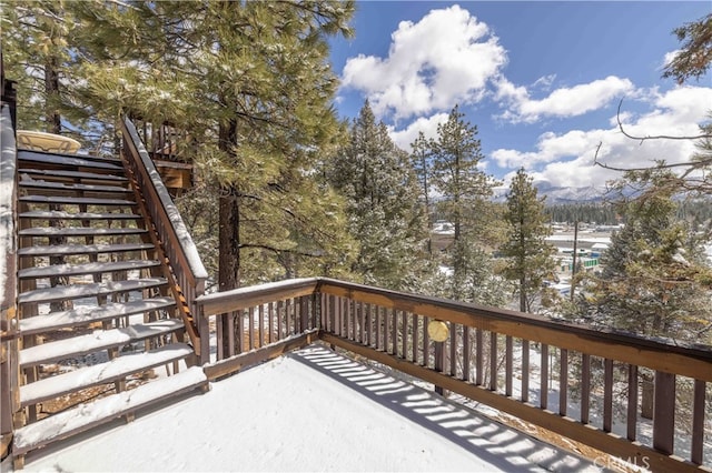 snow covered deck featuring stairs