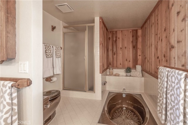 bathroom featuring a textured ceiling, wood walls, visible vents, a shower stall, and a bath