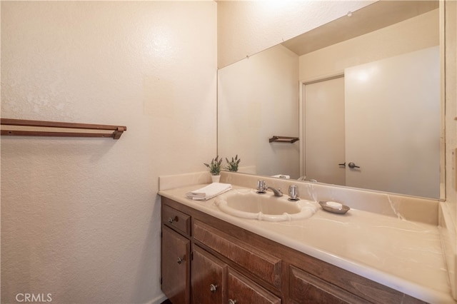 bathroom with a textured wall and vanity