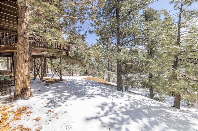 yard covered in snow featuring a wooden deck