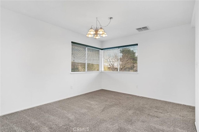 carpeted spare room featuring a chandelier and visible vents