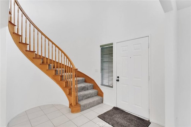 foyer featuring tile patterned floors and stairs