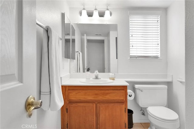 bathroom with tile patterned flooring, vanity, and toilet