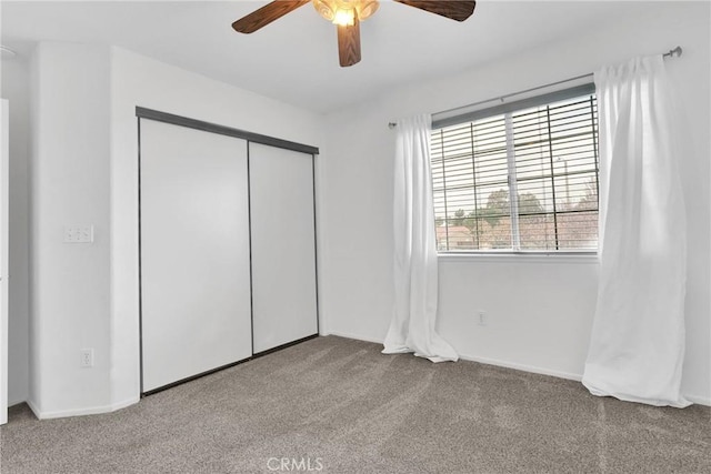 unfurnished bedroom featuring carpet floors, a closet, and a ceiling fan