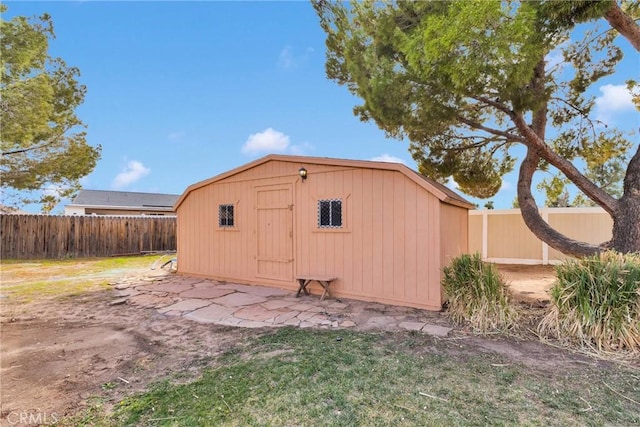 view of outdoor structure with a fenced backyard and an outbuilding