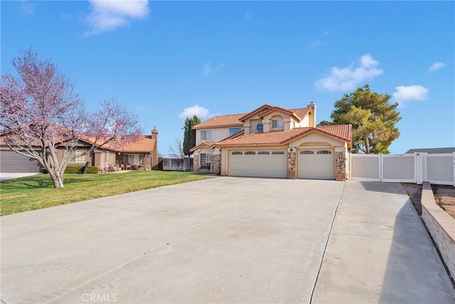 view of front of house with a tiled roof, a front lawn, an attached garage, and fence