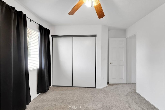 unfurnished bedroom featuring carpet floors, a ceiling fan, and a closet