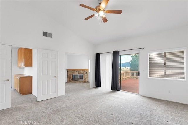 unfurnished living room featuring visible vents, a ceiling fan, light colored carpet, a fireplace, and high vaulted ceiling