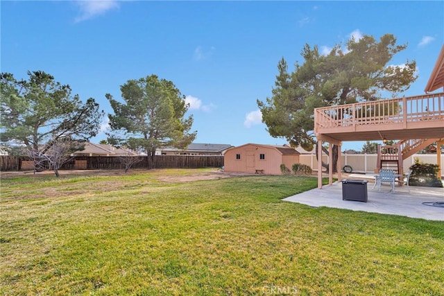 view of yard with a deck, a patio area, an outdoor structure, and a fenced backyard