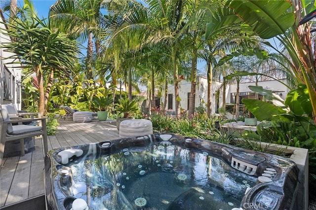 wooden deck featuring hot tub deck surround