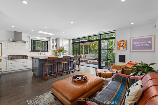 living area with dark wood finished floors, recessed lighting, a healthy amount of sunlight, and expansive windows