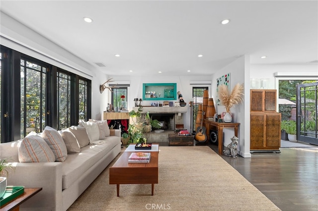 living room featuring a fireplace, recessed lighting, and wood finished floors