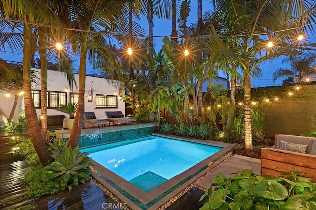 outdoor pool with fence and a patio area