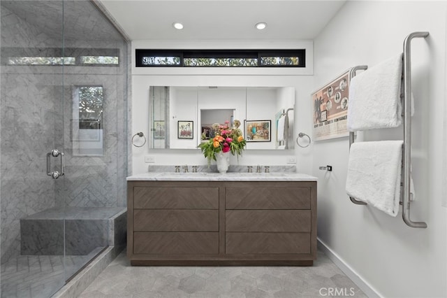 full bathroom featuring double vanity, baseboards, a shower stall, and a sink