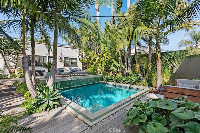 pool featuring a deck and a fenced backyard