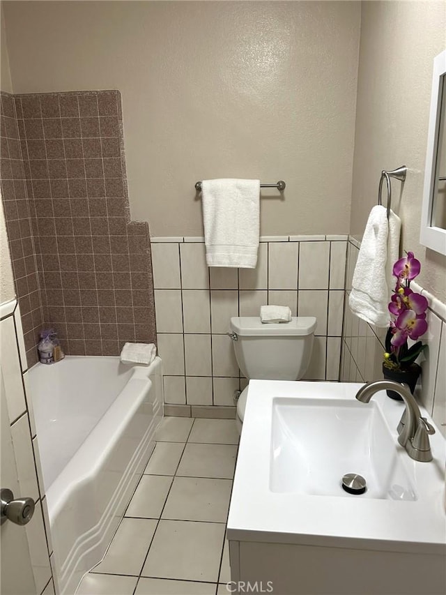 full bath featuring a wainscoted wall, tile walls, a sink, and tile patterned floors