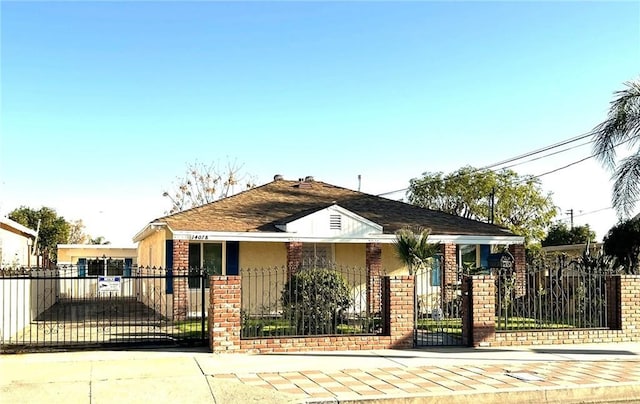 view of front facade featuring brick siding, a fenced front yard, and a gate