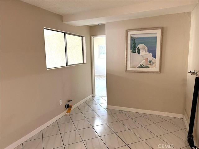 spare room with light tile patterned floors and baseboards