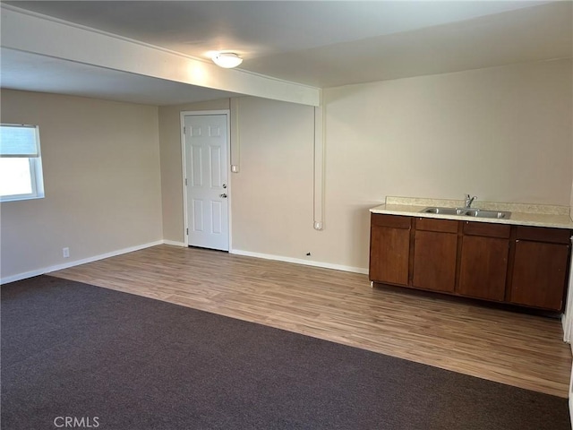 bar with dark wood-type flooring, dark carpet, a sink, and baseboards