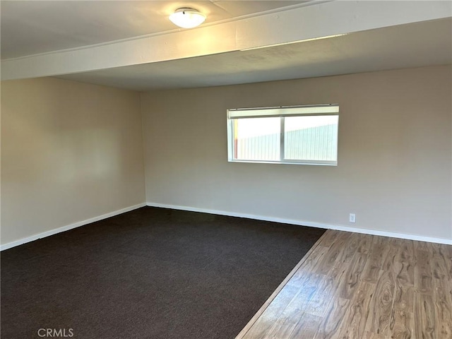 empty room featuring wood finished floors and baseboards