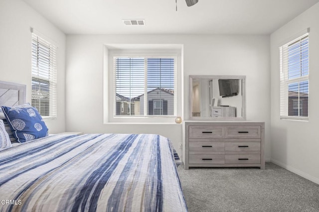 bedroom featuring a ceiling fan, visible vents, baseboards, and carpet flooring