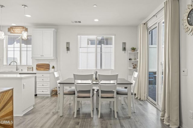 dining area with light wood-style floors, visible vents, and recessed lighting