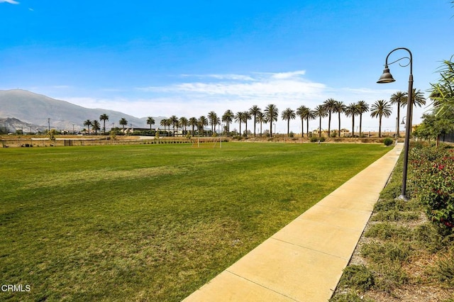 surrounding community with a yard and a mountain view