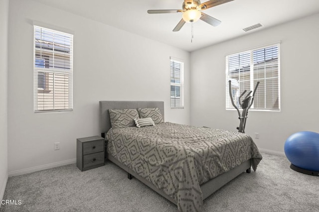 bedroom with light carpet, ceiling fan, visible vents, and baseboards