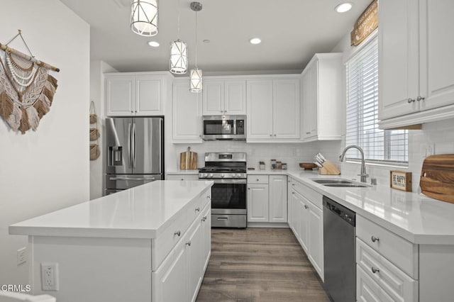 kitchen featuring stainless steel appliances, white cabinetry, a sink, and tasteful backsplash