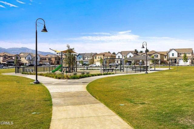 view of property's community featuring playground community, a residential view, a lawn, and a gazebo