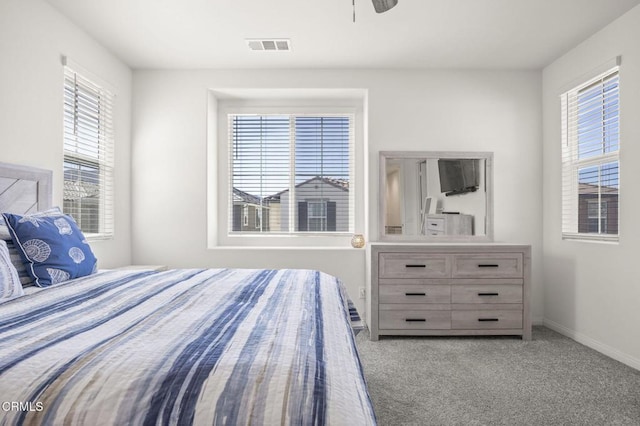 carpeted bedroom featuring visible vents, baseboards, and a ceiling fan