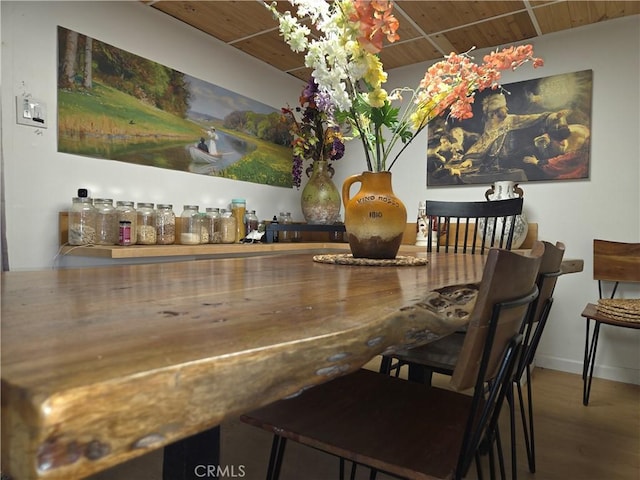 dining room with wooden ceiling, baseboards, and wood finished floors