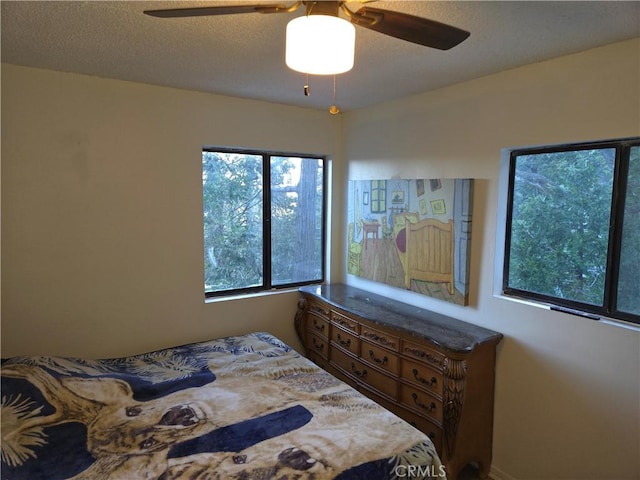 bedroom with a textured ceiling and a ceiling fan