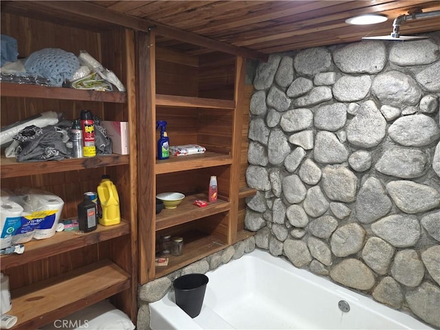 bathroom with a bathing tub and wooden ceiling