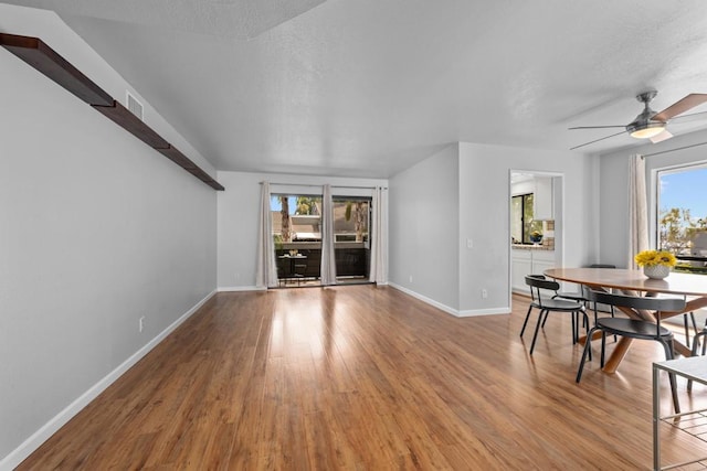 interior space with visible vents, a textured ceiling, light wood-type flooring, and baseboards