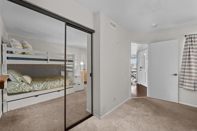 bedroom with a closet, baseboards, visible vents, and carpet floors