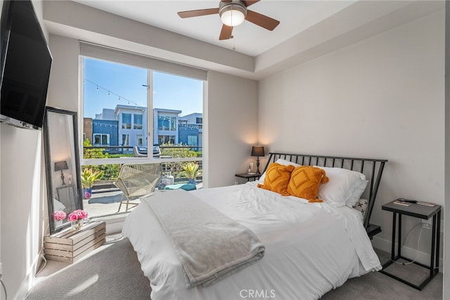 carpeted bedroom with a view of city, ceiling fan, and baseboards