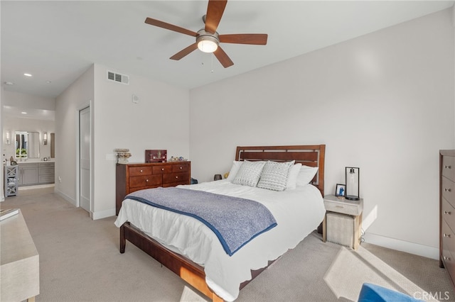 bedroom featuring light colored carpet, visible vents, connected bathroom, and baseboards