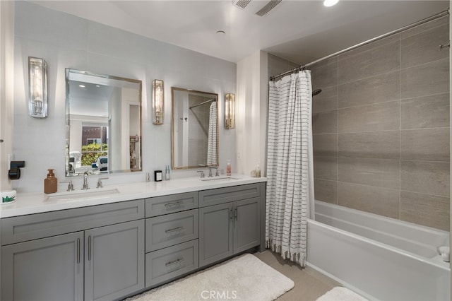 full bathroom featuring double vanity, shower / bath combo with shower curtain, a sink, and visible vents