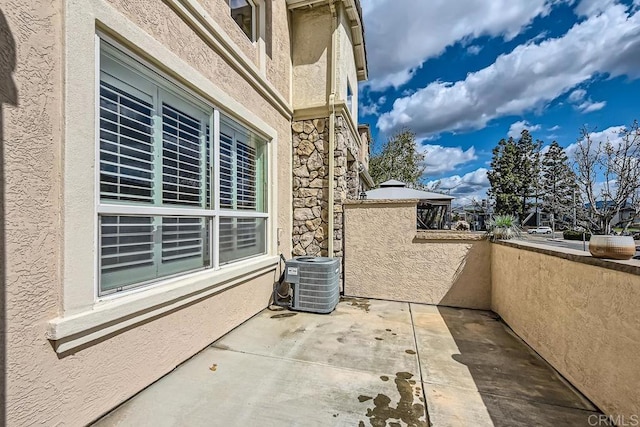 view of patio / terrace with central air condition unit and a balcony