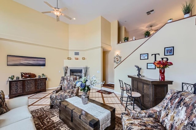 living area featuring a fireplace, tile patterned flooring, and visible vents