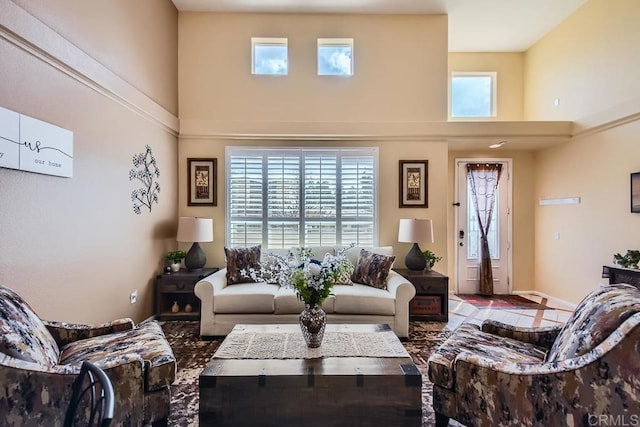 living area with a towering ceiling and baseboards